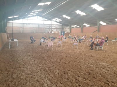 Seminar in der Reithalle: Teilnehmende sitzen mit Abstand auf Stühlen verteilt